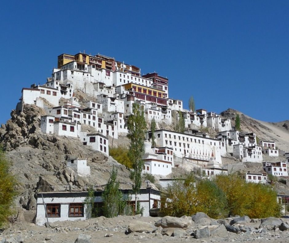 A tranquil monastery is located on a mountain peak, offering stunning vistas of the surrounding natural beauty.